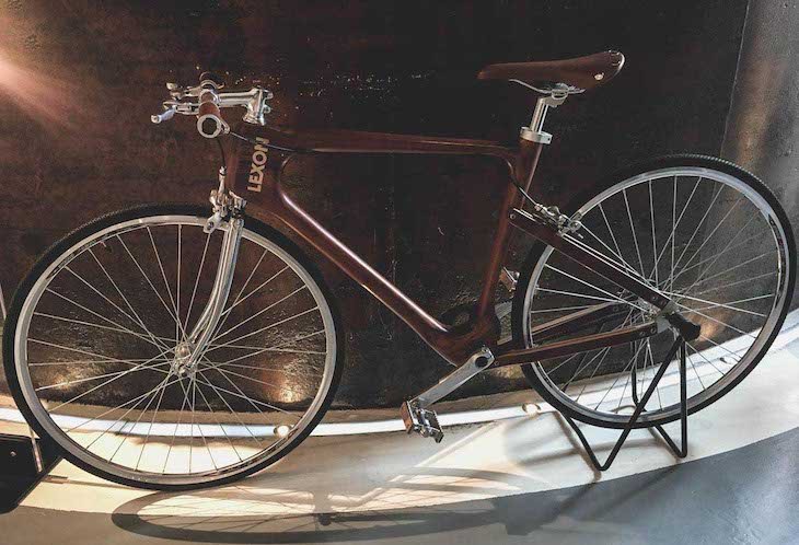 A brown sports bicycle with aluminium front fork exposed