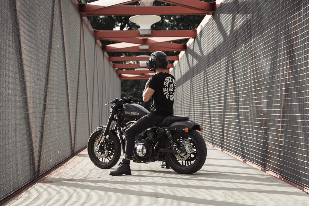 Biker wearing motorcycle jeans from Pando Moto posing on his Harley Davidson Iron