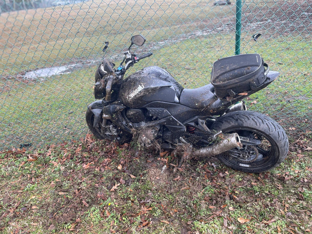 Fallen motorcycle on muddy roadside—the real-world crash setting illustrating risk from slippery patch.