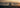 Motorcyclist riding alone at sunset along a beach or open road—evoking the feeling of a warm, comfortable summer ride.