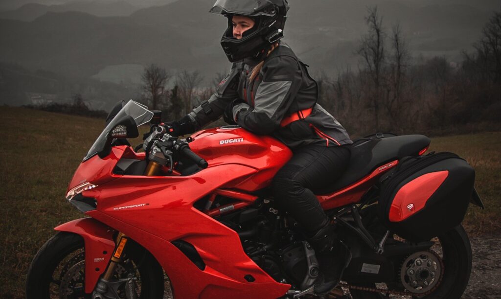 Woman who wears Pando Moto jeans riding a red Ducati