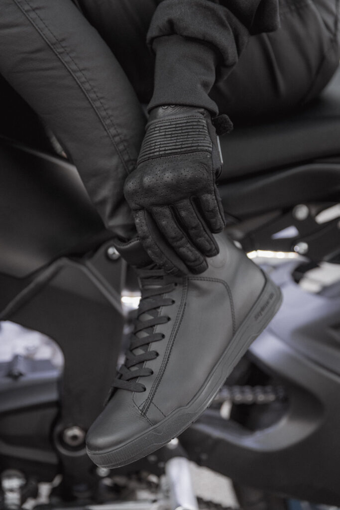 man checking his motorcycle shoes before learning how to ride a motorcycle