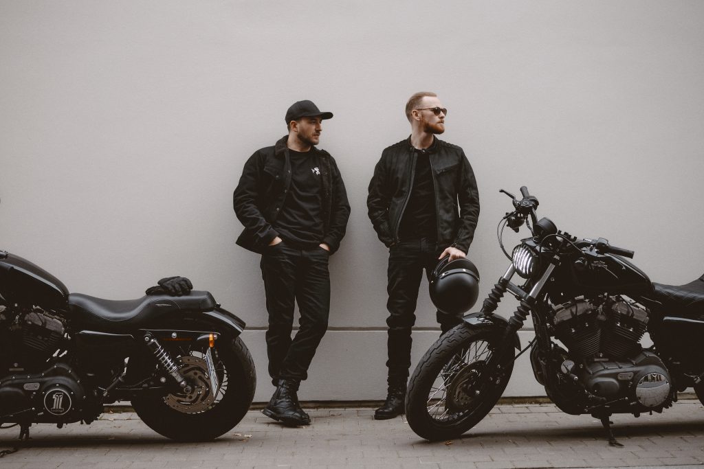 two men before learning how to ride a motorcycle in a closed lot